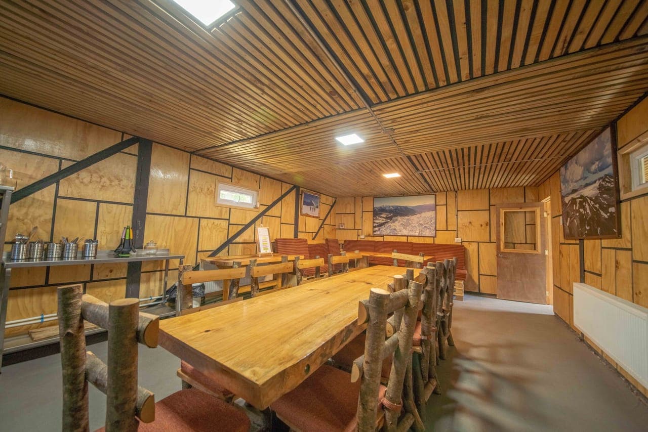Comedor común con mesa larga de madera nativa